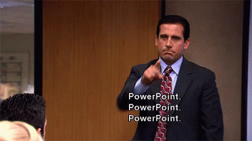 A man in a business suit stands in an office and points at multiple people. The caption reads, "PowerPoint. PowerPoint. PowerPoint."